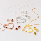 Custom engraved bead necklace shown in gold, silver, and rose gold with name beads