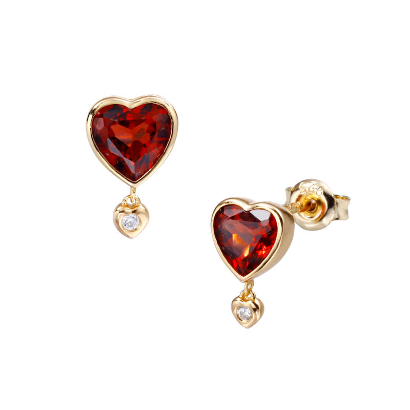 Close-up of red garnet heart earrings set in sterling silver