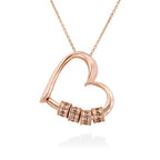 Rose gold personalized heart necklace with engraved beads on white background