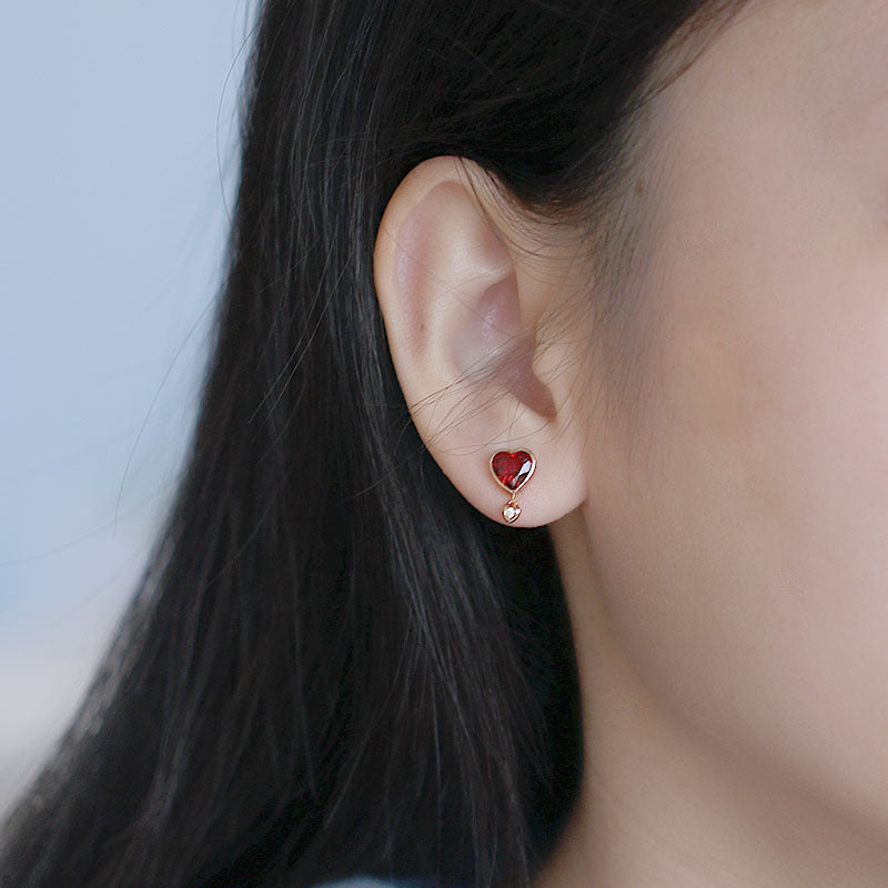 Model wearing garnet heart stud earrings in 925 sterling silver, January birthstone jewelry