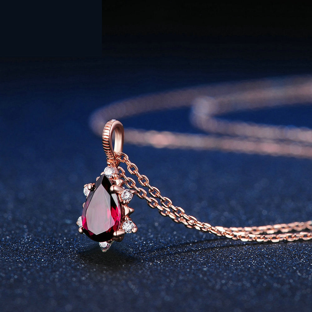 Close-up of garnet drop pendant set in polished 925 sterling silver, highlighting the rich red gemstone
