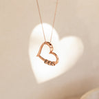 Personalized heart necklace with engraved beads hanging with heart-shaped shadow