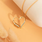 Gold personalized name necklace with engraved heart beads on elegant background